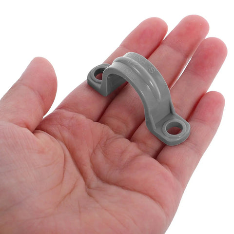Killer Grip 20 Pack PVC Pipe Clamps Half Inch Conduit Straps held in hand showing heavy duty grey plastic mount for wiring.