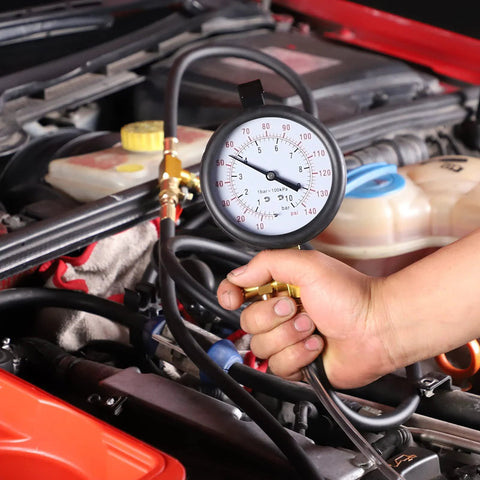 Front view of BETOOLL Pro fuel injection pressure tester gauge 0-140 psi with brass fittings held over car engine bay