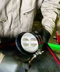 Technician using Adjustable Piston Ring Compressor Tool Fits 3.5 To 7 Inch Pistons With Spring Steel Body And Quarter Inch Drive Adjuster.