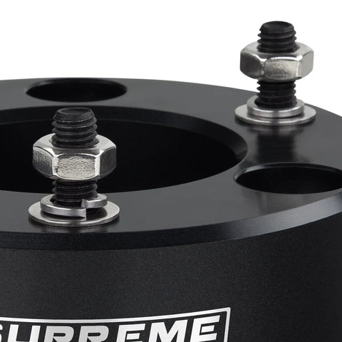 Close-up of T6 billet aluminum strut block for leveling kit, featuring adjustable bolts and a smooth finish.