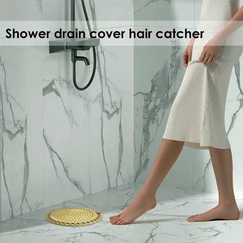 Gold Stainless Steel Shower Drain Catcher With Soft Silicone Edge Flat Round Tub Strainer placed in a bathroom with a woman stepping over it.