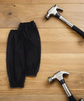 Black Waterproof Arm Sleeves Two Pack Heavy Duty Grease Shield For Mechanics And Construction Crews on wooden background with hammers.
