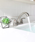 Two Handle Deck Mounted Bathroom Sink Faucet With Brushed Nickel Finish in modern bathroom setting with flowing water