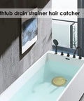Gold Stainless Steel Shower Drain Catcher With Soft Silicone Edge Flat Round Tub Strainer in a modern bathtub.