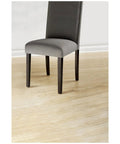 Gray chair on hardwood floor protected by Beige 32 Piece Round One Inch Felt Furniture Pads With Self Stick Adhesive Protect Hardwood Floors From Nicks Dents And Scratches While Moving Furniture Like A Pro.