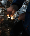 Hands using Beast Fire Starter Survival Kit With Four Ferro Rods In 4 Inch, 3.2 Inch And Two 2.4 Inch Sizes for igniting sparks outdoors.