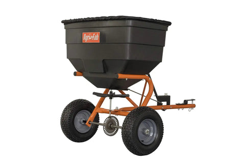 Tow Behind Lawn And Garden Broadcast Spreader With 185 Lb Capacity, showing orange frame and large wheels