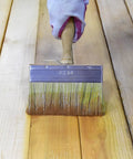 Person using 5.5 Inch Limewash Deck Brush With Wood Handle Large Paint Applicator For Walls Wood Fences And Floors Staining And Painting Ideal For Limewash And Deck Stains on wooden floor