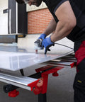 Man using Heavy Duty Adjustable Tile Table For Large Format Ceramic Sheets Extending 43 To 59 Inches for cutting large ceramic sheet.