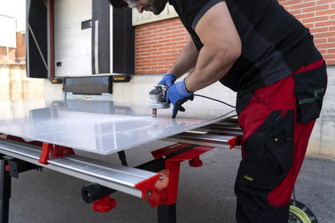 Man using Heavy Duty Adjustable Tile Table For Large Format Ceramic Sheets Extending 43 To 59 Inches for cutting large ceramic sheet.