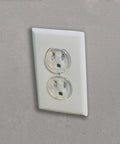 Super Stealthy Child Proof Outlet Covers 12 Pack Ultra Clear Plastic Electrical Safety Plugs in a standard outlet.