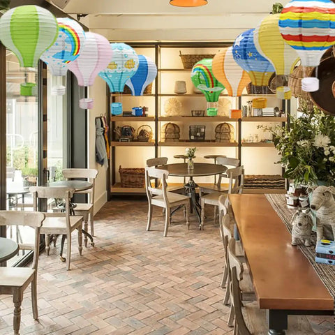 Colorful And Lit 12 Inch Hanging Hot Air Balloon Paper Lanterns Set Of 10 Reusable Party Lamps For Wedding Birthday Anniversary Christmas Engagement Decor Indoors Or Outdoors in a cozy cafe setting
