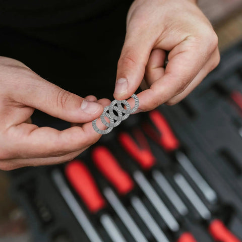 Set Of Twenty M10 Wedge Locking Washers Built Tough With Premium Manganese Steel for automotive applications held in hands.