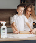 Mother and child in kitchen with All Purpose Cleaner Spray For Home And Kitchen Multipurpose Multisurface Cleaner For Glass Countertops Appliances Upholstery And More Unscented 32oz Pack Of 2 on countertop.
