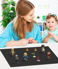 Mother and child playing with small figures on a magnetic receptive sheet on the table in a bright room.