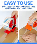 Rock Solid Heavy Duty Crystal Clear Packing Tape With Badass Industrial Adhesion For Moving Boxes Shipping Supplies And Cartons That Absolutely Will Never Tear Or Peel in use with tape dispensers on a cardboard box.