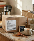 Box labeled 'Spiced Chai Mix', cups with Creamy Instant Chai Latte Powder Mix For Hot Or Iced Drinks, Sweet Spiced Black Tea Latte.