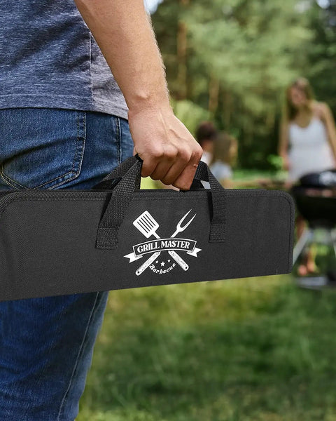 Person holding 'Grill Master' bag for Stainless Steel 4 Piece BBQ Tools Set With Tongs Fork Spatula Brush And Carrying Bag For Grillin Durable Backyard Grillin Gear The Ultimate Gift For Men Dad Husband Birthday outdoors.