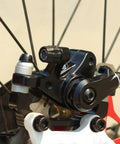 Beefy Mechanical Disc Brake Kit For Mountain Bikes And Road Cycles with aluminum caliper mounted on a wheel.