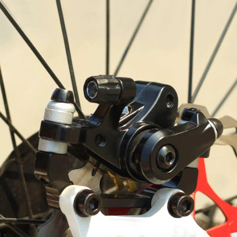 Beefy Mechanical Disc Brake Kit For Mountain Bikes And Road Cycles with aluminum caliper mounted on a wheel.