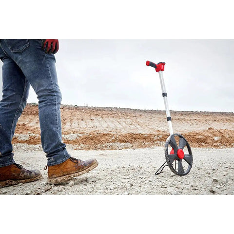 12 Inch Digital Measuring Wheel Smooth Rolling Yard Tracker With Pistol Grip Handle Rubber Tread And Clear Screen Display on a job site.