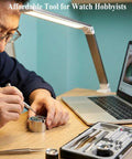 Person using Watch Movement Holder For NH35 NH36 7S26 7S36 4R Pro Grade Movement Base Repair Tool with tools and laptop nearby
