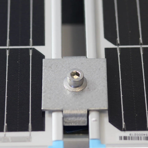 Close-up of Solar Panel Mid Clamps for One and Five Eighth Inch Steel Strut Channel Kit with Cone Nuts installed on solar panel.