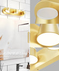 Gold rotatable wall lamp above bathroom mirror with up and down illumination, detailed view of light heads and fixture design.