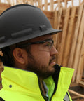 Worker wearing Ridgeline Full Brim Hard Hat With 4 Point Ratchet Suspension Matte Black Graphite Pattern on construction site