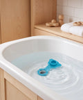 Silicone Bathtub Plug Stopper for Bath Tubs Blue floating in water inside a modern bathtub, showing smooth surface and design.