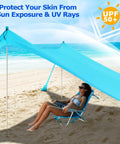 Beach Tent Sun Shelter 10x10ft Pop Up Canopy With UPF50 Plus Shade on a sunny beach, sheltering a person, with windproof poles.