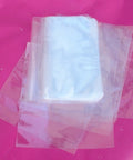 500 Pcs 4X6 Inch Polyolefin Heat Shrink Film Wrap Flat Bags With Vent Hole stacked on a pink background.