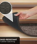 Hand lifting skid-resistant carpet stair tread to show non-slip rubber backing for safer stairs, pebble gray, 8x27 inches.