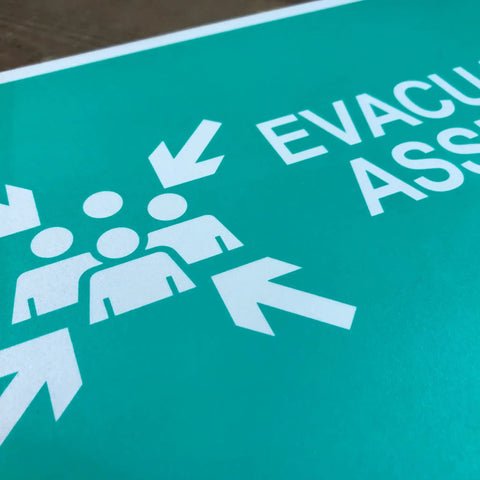 No Nonsense Heavy Duty Reflective Emergency Assembly Point Sign with evacuation graphic and directional arrows.