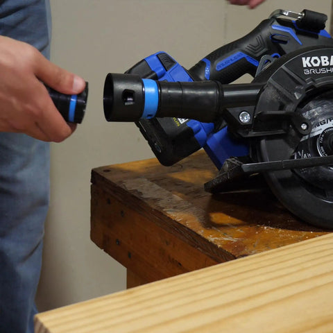 Expanded Multi Brand Power Tool Dust Collection Adapter Kit With Quick Click System attached to power tool on workbench