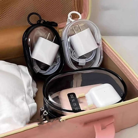 Clear Waterproof Travel Pouch For Phones And Chargers Slick Zip Closure Cable Organizer Rigid Shell, containing chargers and cords in a suitcase.