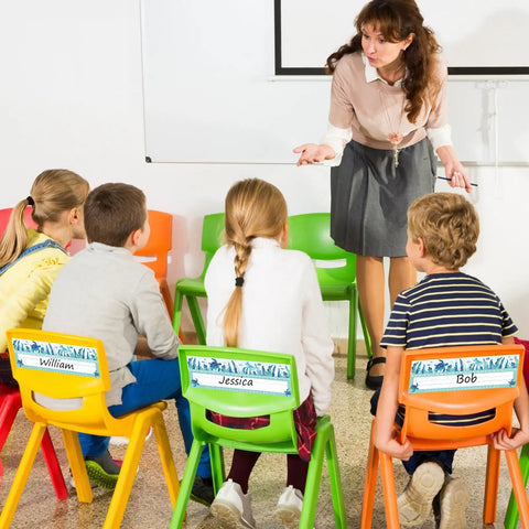 Children seated on colorful chairs with 60 Pack Ocean Themed Sea Animal Name Tag Stickers For Back To School Marine Life Adhesive Labels.