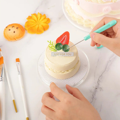 Level Up Your Sweet Baking Game With This Solid Acrylic Cookie Decorating Turntable Kit That Comes Loaded With Scribe Needles Soft Brushes Grip Mats And Rubber Feet For Flawless Icing Every Time. Close-up of hands using scribe needle on a decorated cake.