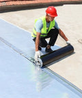 Worker applying Heavy Duty Roof Repair Tape With Aluminum Foil, 0.07 Inch Thick Roll on a flat roof.
