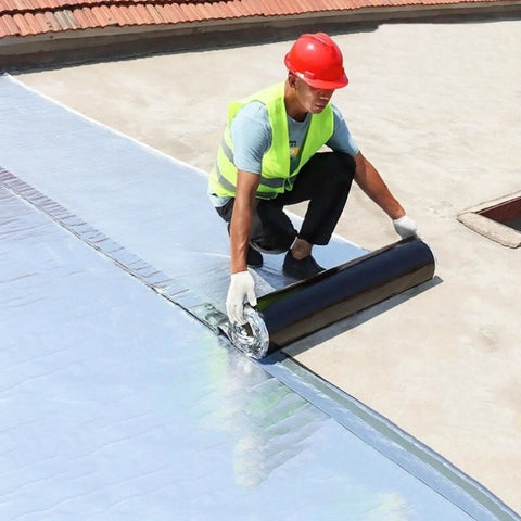 Worker applying Heavy Duty Roof Repair Tape With Aluminum Foil, 0.07 Inch Thick Roll on a flat roof.