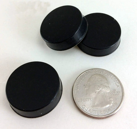 Three black Sorbothane Heavy Duty Vibration Isolation Circular Disc Pads 0.25 Inch Thick 1 Inch Diameter with a quarter for scale