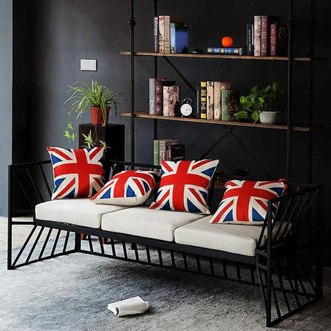 Modern black metal sofa with Union Jack cushions in stylish living room, showcasing decor and design elements.