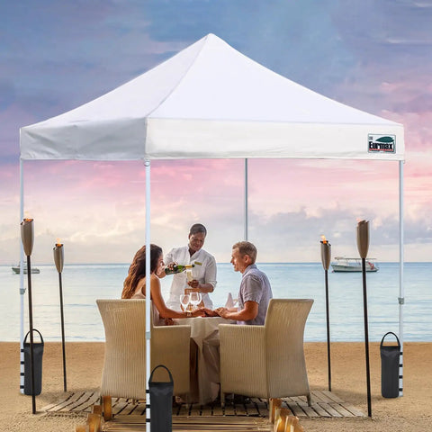 Beach setup with table under tent, stabilized by 4 Pack 125 Lb Universal Canopy Weights For Instant Shelters, beefy sandbags.