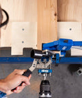 Person using MortiseMate Loose Tenon Jig For Woodworking Easy Mortise Cutter with drill for precise joinery on wooden workbench