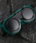 Four Pack Welding Safety Goggles With Flip Up Design Kickass Arc Light Protection No Sweat Ventilation For Industrial Work on textured surface.