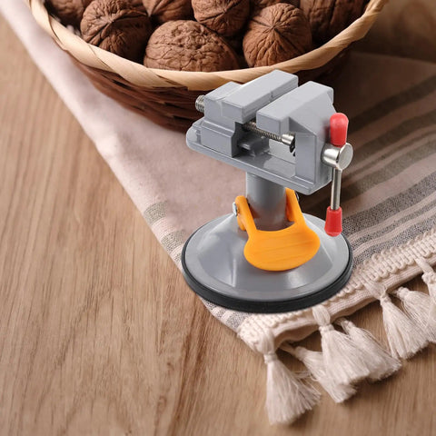 Mini Vise Clamp With Suction Mount Fully Rotatable Bench Vise for Woodworking on table with walnuts in basket