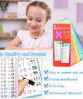 Child using Add Up Fast 1 To 12 Addition Flash Cards Set With Large Times Table Chart; markers and colorful cards visible.