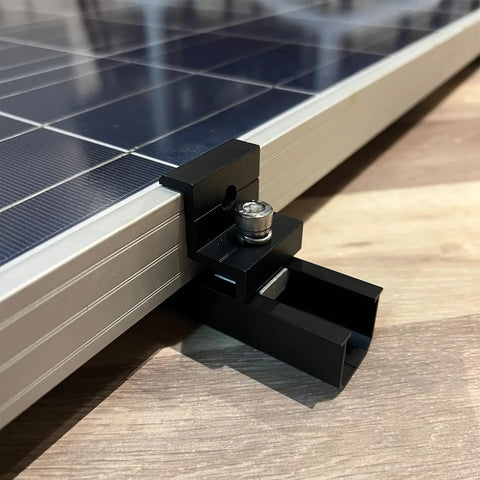 Close-up of black aluminum clamp from Solar Panel Mounting Brackets Roof Kit With Rails And Clamps For 1.18 To 1.38 Inch Panel Thickness A Row Roof Assembly On Tin Or Flat Sheet Rooftops Aluminum Alloy 4 Pack Black securing panel edge.