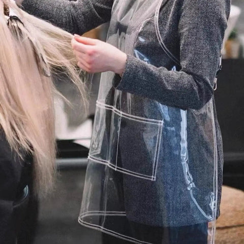 Stylish use of transparent waterproof hair stylist apron with adjustable straps in action at salon, durable rustproof pockets visible