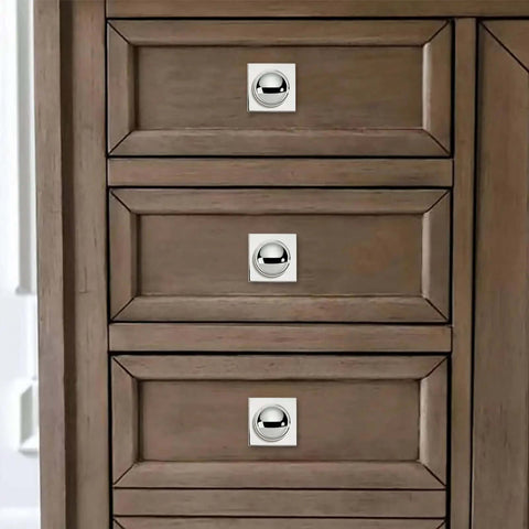 Close-up of heavy duty one and a half inch cabinet knobs with back plate polished nickel finish on wooden drawers.